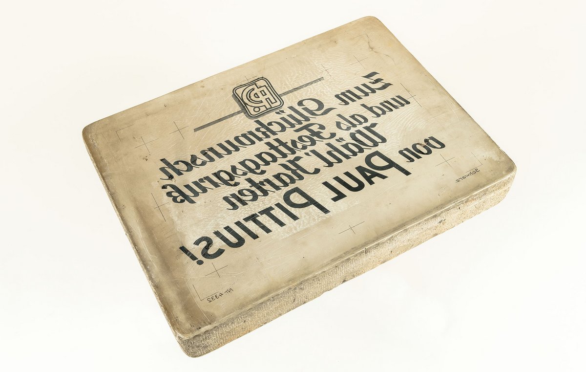 Druckstein mit Werbeslogan der Firma Paul Pittius: Zum Glückwunsch und als Festtagsgruß wähl Karten von Paul Pittius