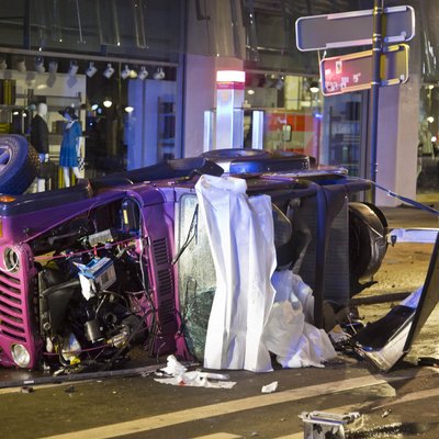Der verunglückte rosa Jeep liegt auf der Seite, dahinter hängt ein Banner mit einem Fotos des Kudamms.