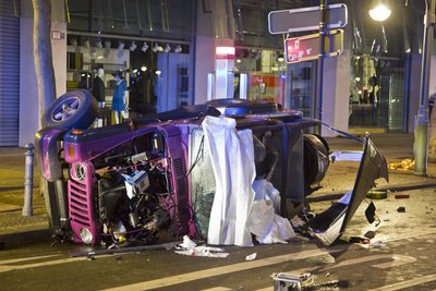 Der verunglückte rosa Jeep liegt auf der Seite, dahinter hängt ein Banner mit einem Fotos des Kudamms.