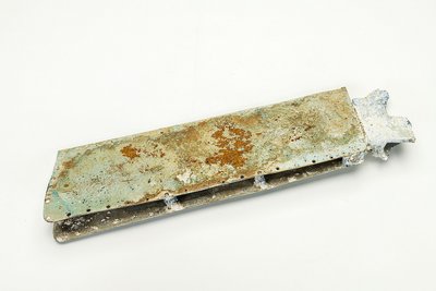 Das Wrackteil einer Flügelbombe aus dem Zweiten Weltkrieg ist aus Metall. Es ist rechteckig und zum Teil verrostet.