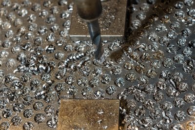 Ein Metallstück, in das kreisrunde Löcher eingefräst sind