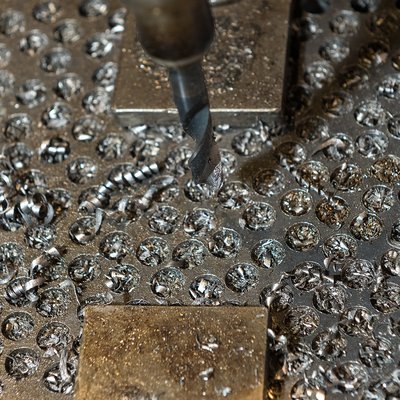 Ein Metallstück, in das kreisrunde Löcher eingefräst sind