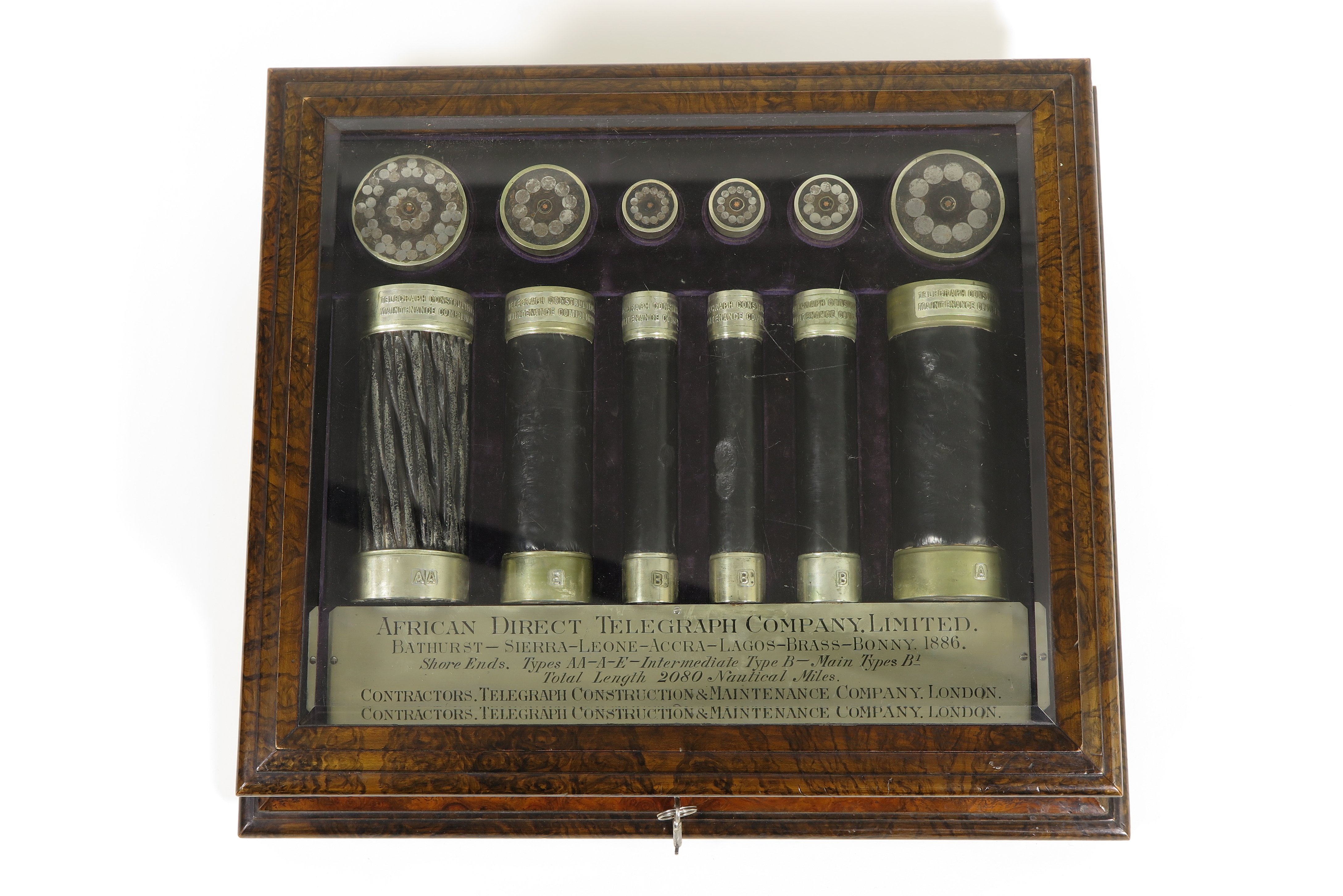Hölzerne Schmuckschatulle der African Direct Telegraph Company mit 12 unterschiedlich großen Teilen von Telegrafenkabeln.