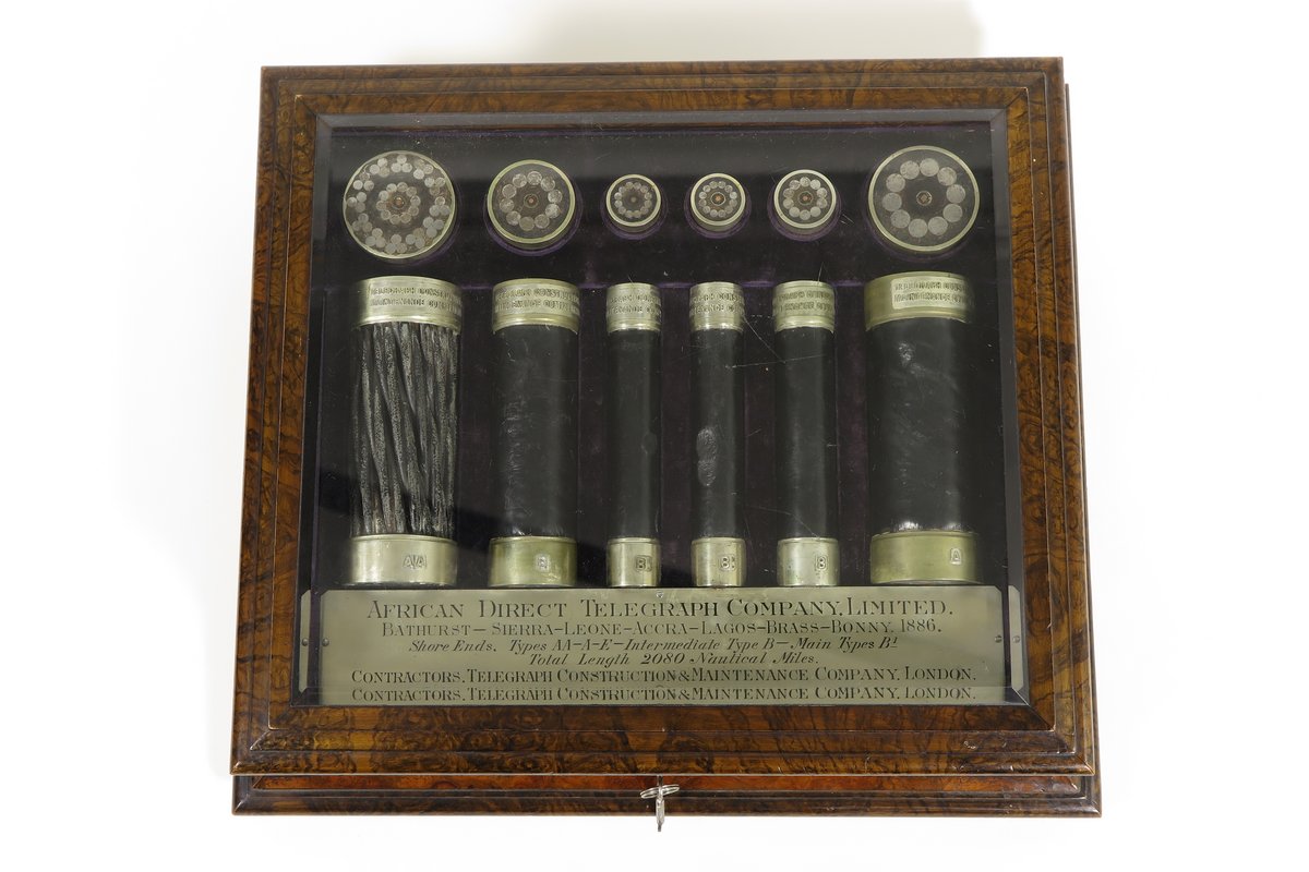 Hölzerne Schmuckschatulle der African Direct Telegraph Company mit 12 unterschiedlich großen Teilen von Telegrafenkabeln.