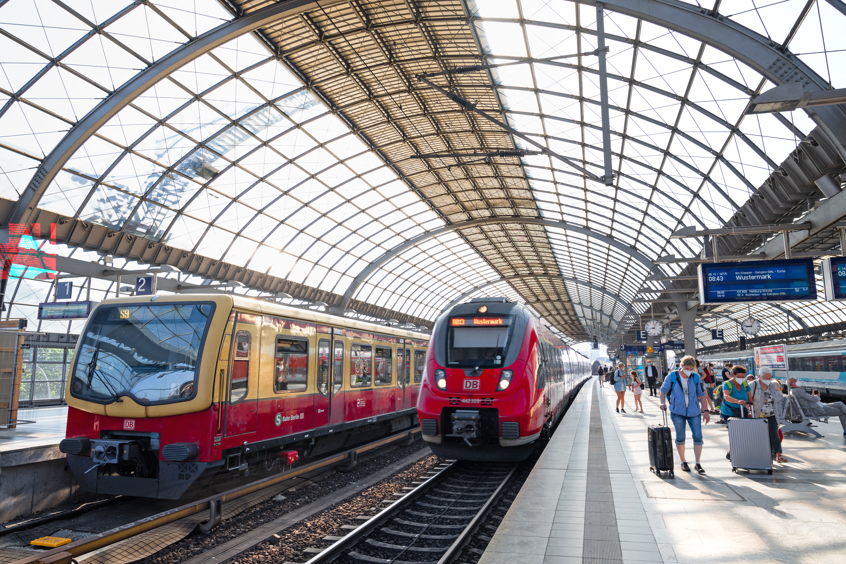 Eine S-Bahn und eine Regionalbahn halten an einem Bahnhof.