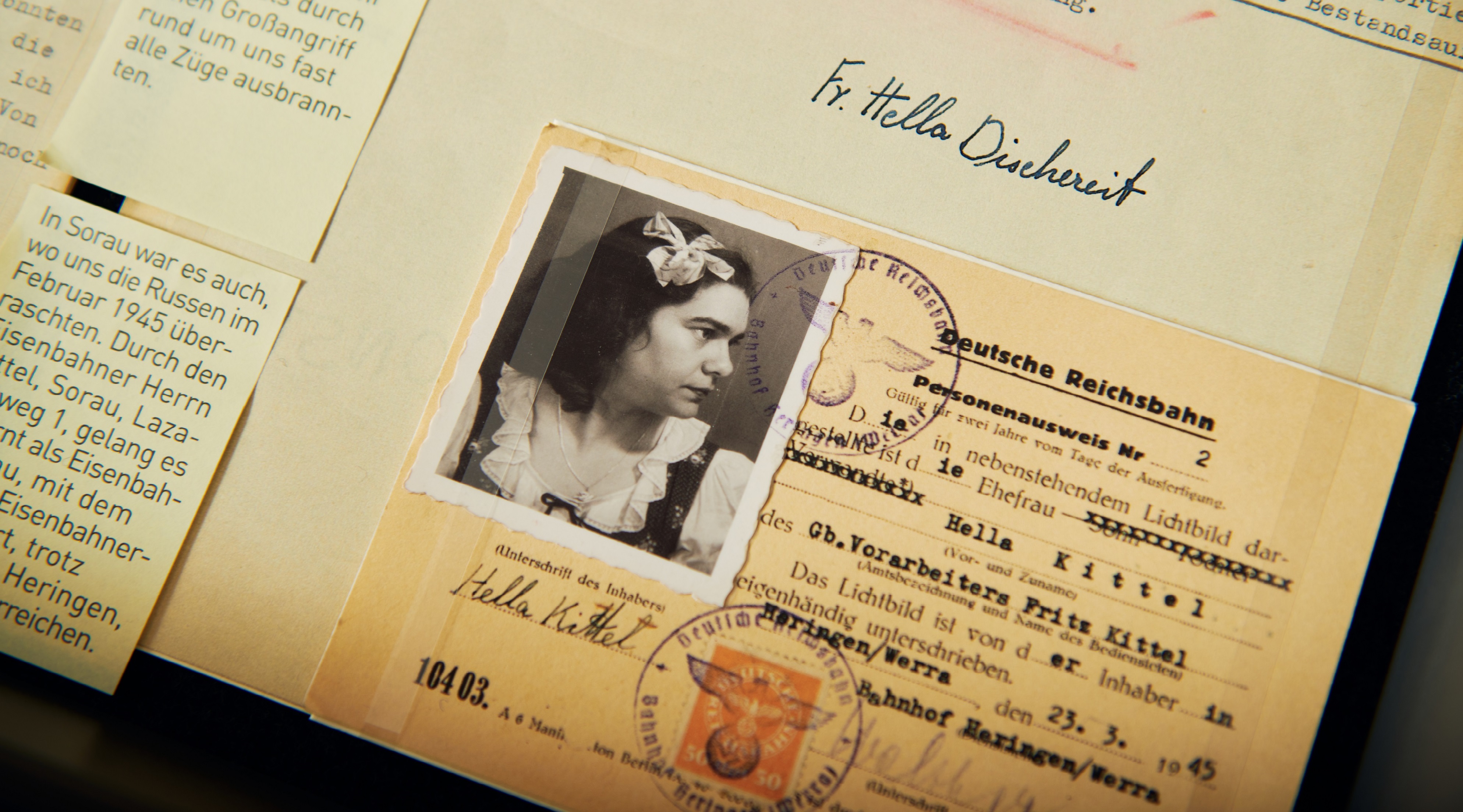 Ein Reichsbahn-Personenausweis, mit dem Foto einer dunkelhaarigen Frau, ausgestellt auf den Namen "Hella Kittel, Ehefrau der Gb. Vorarbeiters Fritz Kittel", datiert auf den 23.03.1945.